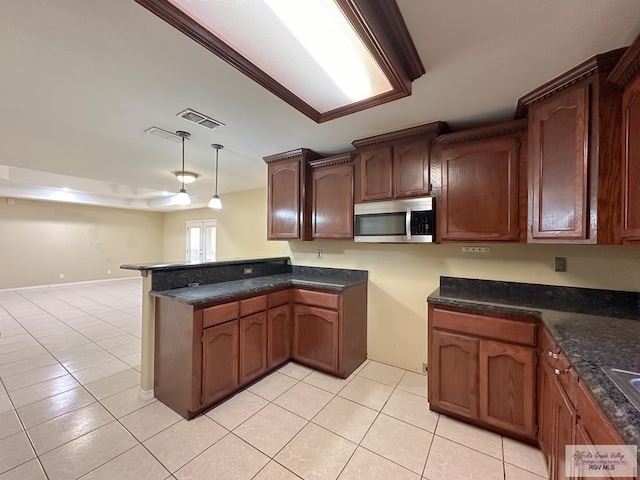 kitchen featuring kitchen peninsula, light tile patterned flooring, and pendant lighting