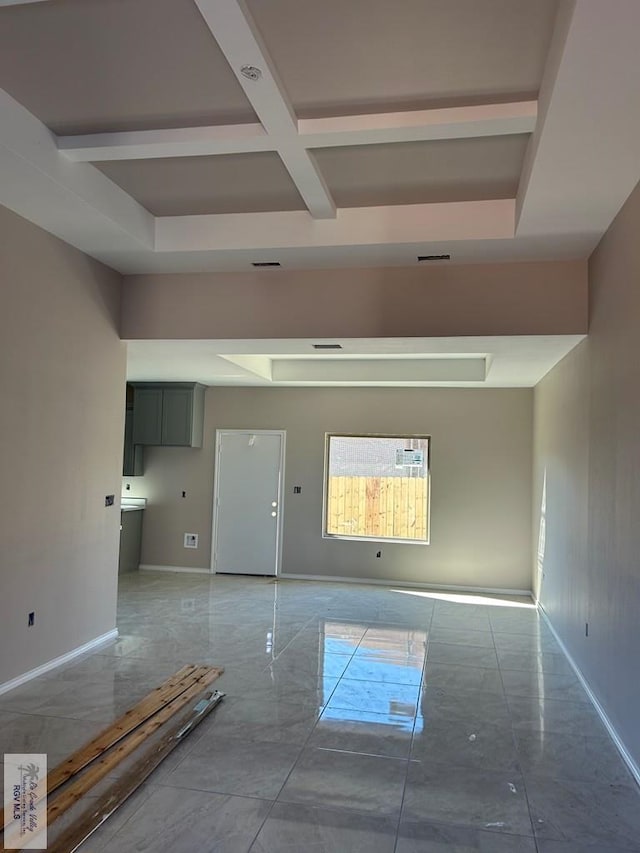 empty room featuring coffered ceiling and beam ceiling