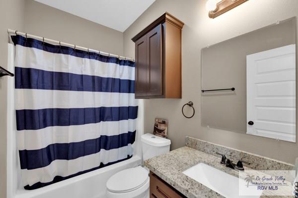 bathroom with toilet, shower / bath combo, and vanity