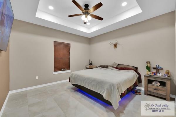 bedroom with recessed lighting, baseboards, a raised ceiling, and ceiling fan