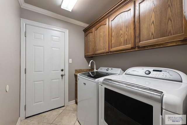 clothes washing area featuring cabinets, washing machine and dryer, light tile patterned flooring, and crown molding