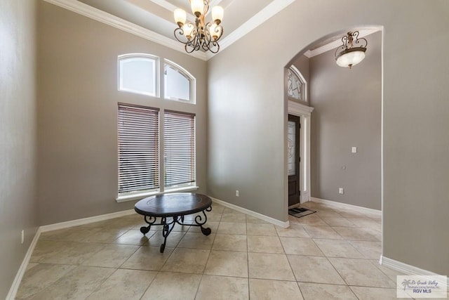 interior space featuring light tile patterned floors, a notable chandelier, ornamental molding, and a towering ceiling