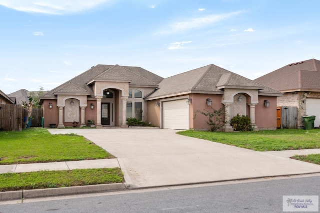 french country inspired facade featuring a garage and a front yard