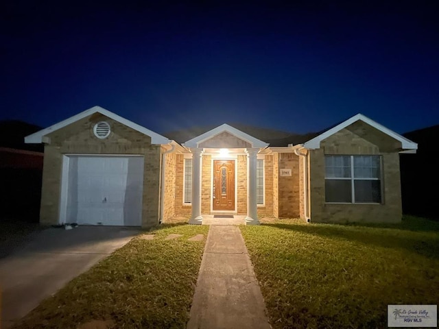 ranch-style house with a garage and a lawn