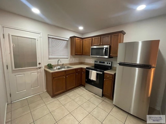 kitchen featuring appliances with stainless steel finishes, light tile patterned floors, and sink