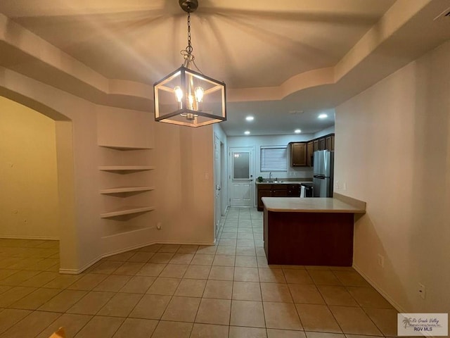 kitchen featuring stainless steel refrigerator, a chandelier, light tile patterned floors, and hanging light fixtures