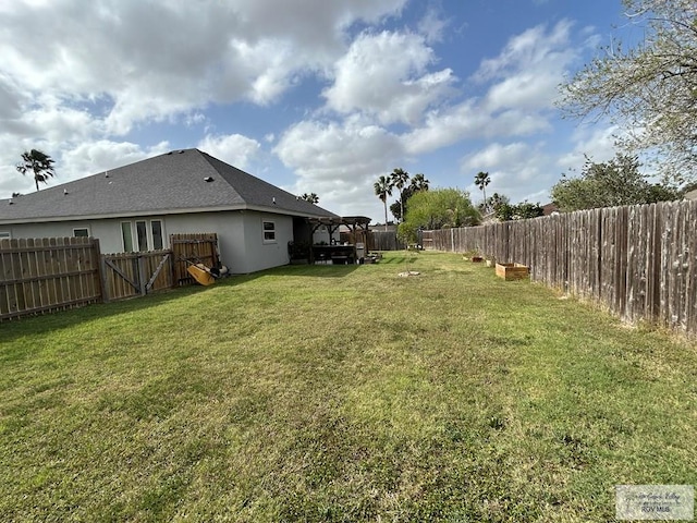 view of yard with a fenced backyard and a gate