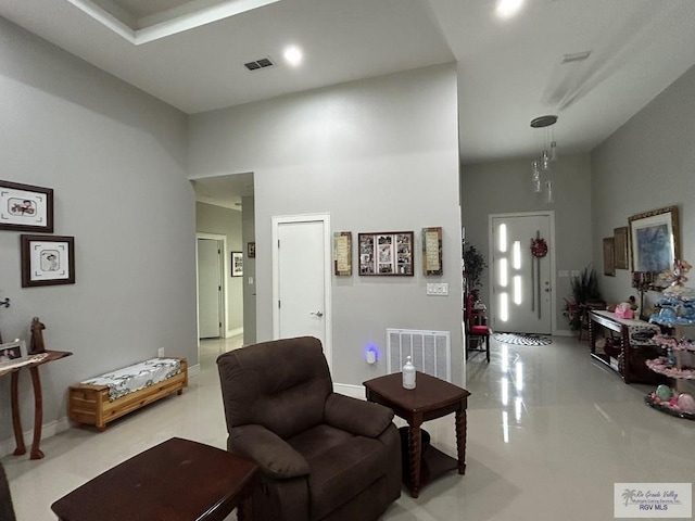 living room featuring a towering ceiling and visible vents