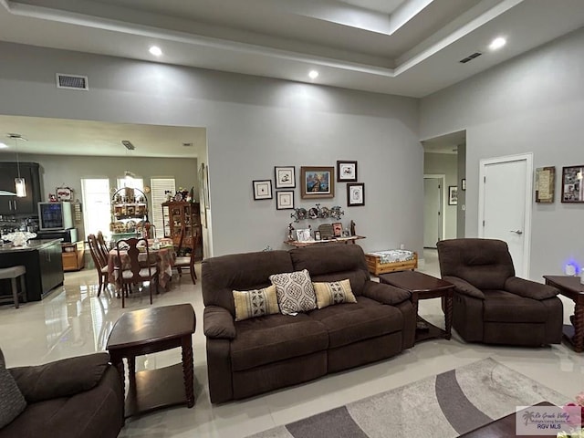 living area featuring a high ceiling, visible vents, and recessed lighting