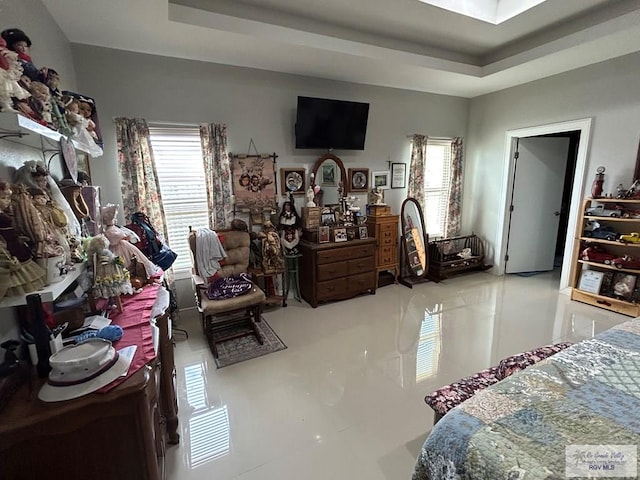 bedroom featuring multiple windows and a tray ceiling