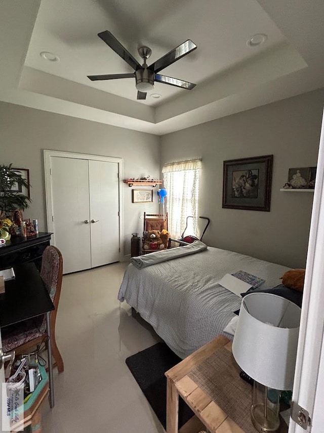 bedroom with a tray ceiling and ceiling fan