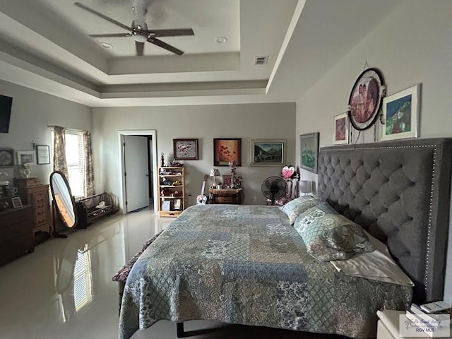 bedroom featuring ceiling fan, a raised ceiling, and visible vents