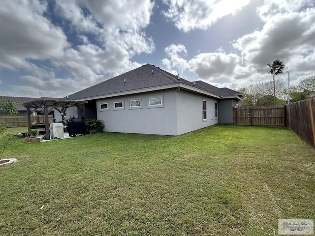 back of property with stucco siding, a fenced backyard, a lawn, and a pergola