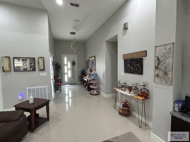 hall featuring baseboards and visible vents