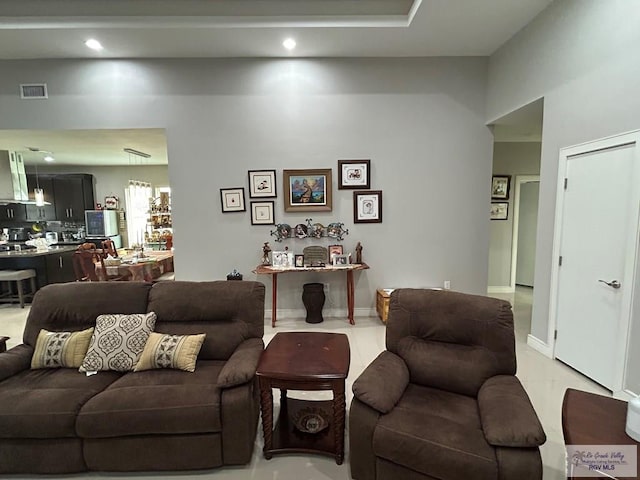 living area featuring baseboards, visible vents, and recessed lighting