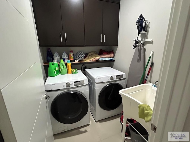 washroom featuring cabinet space, washer and clothes dryer, and a sink