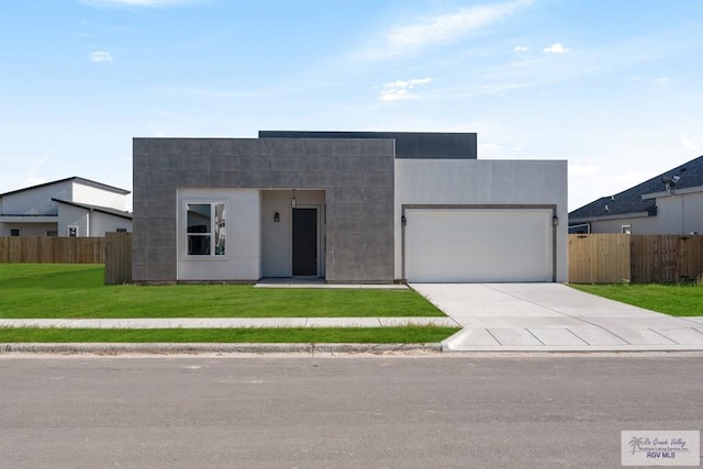 contemporary house featuring a garage and a front lawn