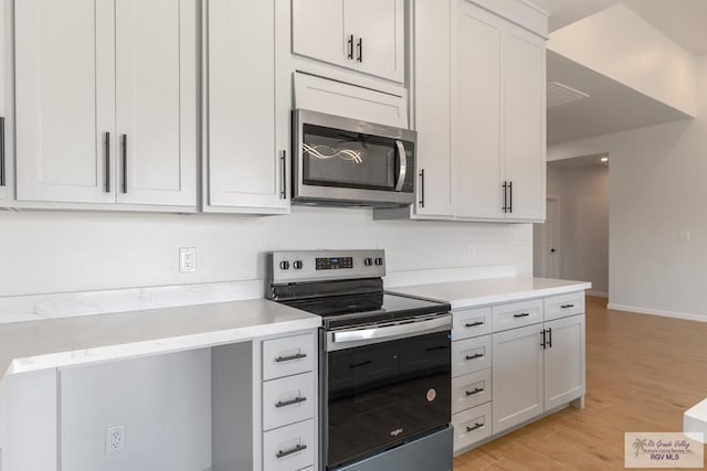 kitchen with white cabinetry, appliances with stainless steel finishes, and light hardwood / wood-style flooring