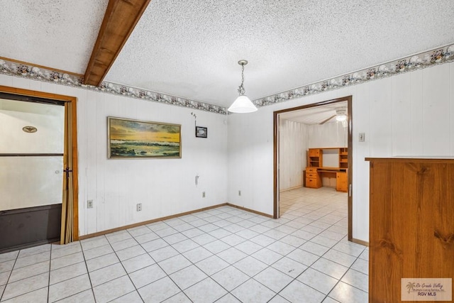 734 Billy Mitchell Blvd, Brownsville, TX 78521 - unfurnished dining area featuring a textured ceiling, light tile patterned floors, baseboards, and beam ceiling