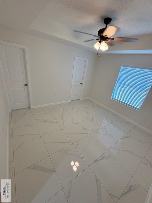 empty room featuring ceiling fan and a textured ceiling