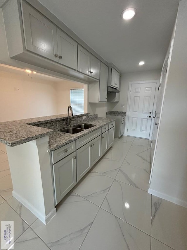 kitchen featuring kitchen peninsula, sink, and gray cabinets