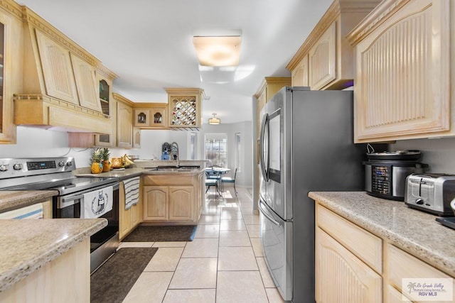 kitchen with light brown cabinets, sink, stainless steel appliances, light tile patterned flooring, and custom range hood