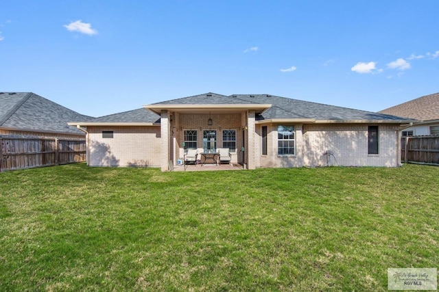 back of house featuring a patio area and a lawn