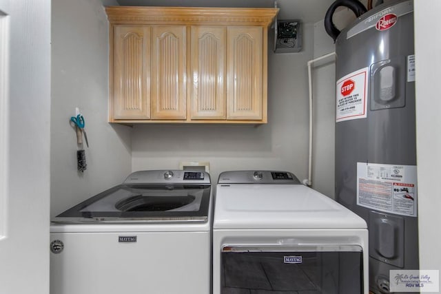 laundry area with cabinets, independent washer and dryer, and water heater