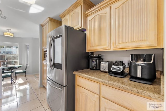 kitchen featuring light brown cabinets, light tile patterned flooring, and stainless steel appliances