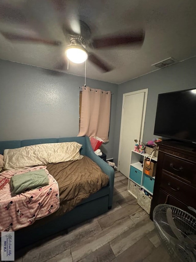 bedroom with light hardwood / wood-style flooring and ceiling fan