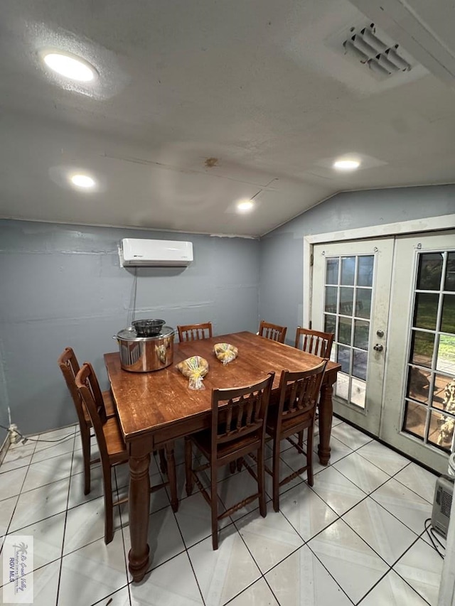 tiled dining space featuring an AC wall unit, lofted ceiling, a textured ceiling, and french doors