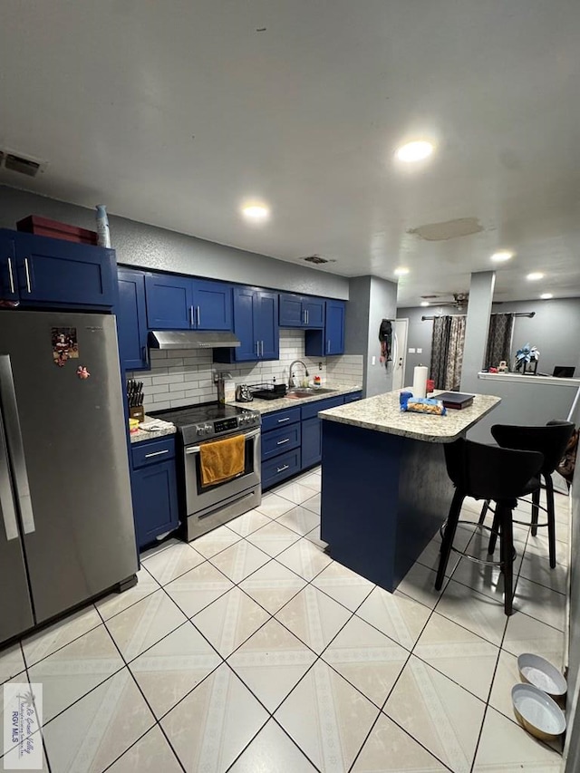 kitchen featuring sink, appliances with stainless steel finishes, backsplash, a center island, and blue cabinets