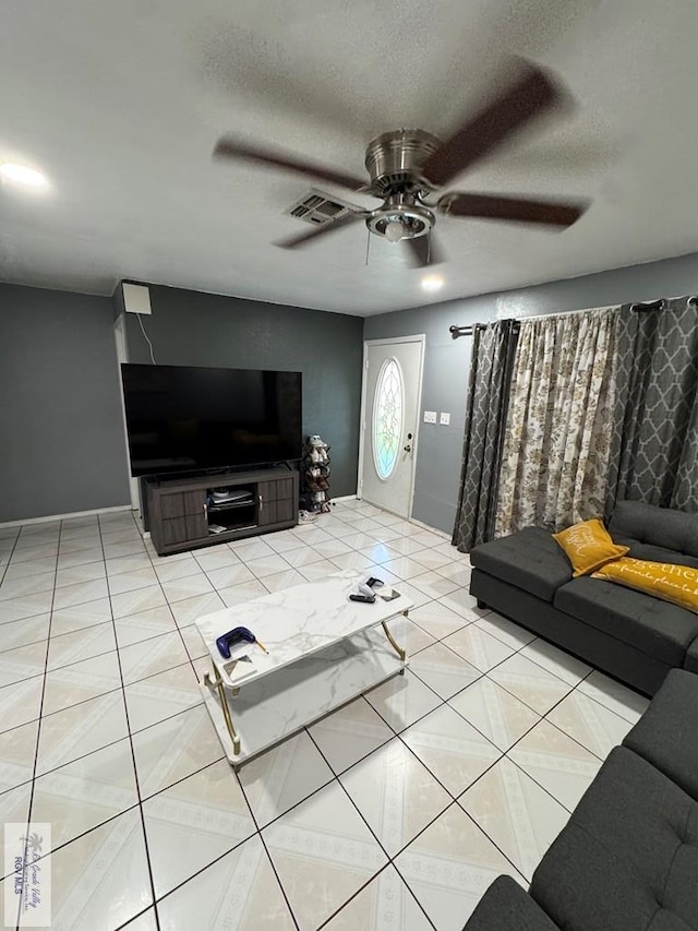 tiled living room with ceiling fan and a textured ceiling