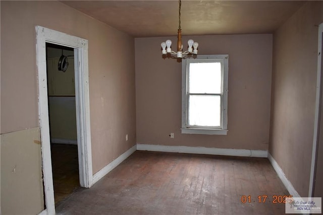 unfurnished room featuring hardwood / wood-style flooring and a chandelier