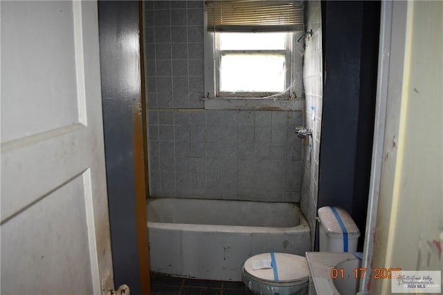 bathroom featuring toilet and tiled shower / bath