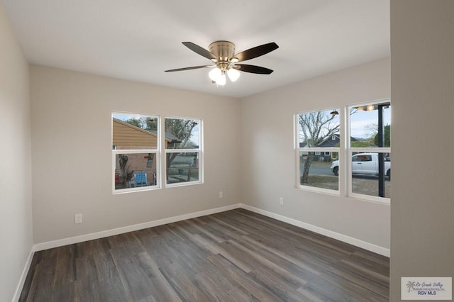 spare room with a healthy amount of sunlight, dark wood-type flooring, and ceiling fan