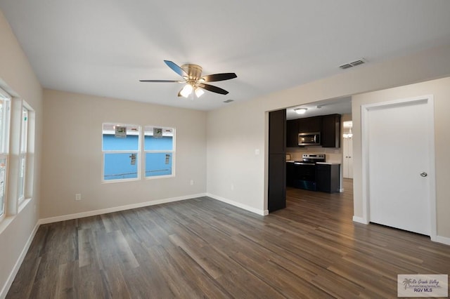 unfurnished living room featuring a healthy amount of sunlight, dark hardwood / wood-style floors, and ceiling fan