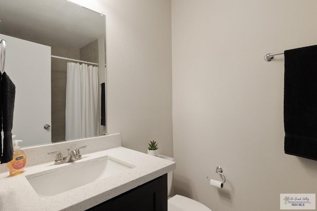 bathroom featuring vanity, toilet, and a shower with shower curtain