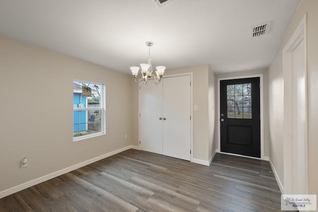 foyer featuring dark wood-type flooring and a chandelier