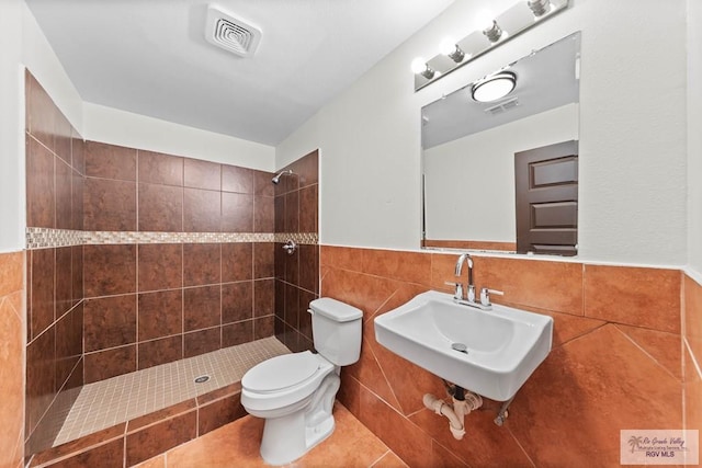 2307 Carlos Ave, Brownsville, TX 78526 - bathroom featuring a tile shower, a sink, visible vents, and tile walls