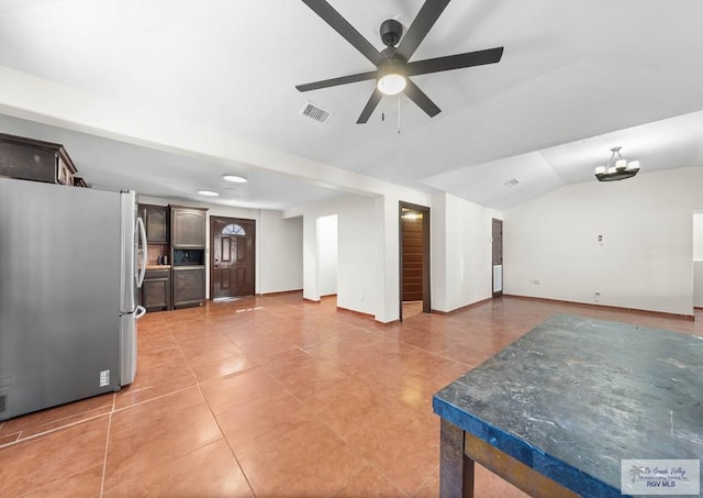 2307 Carlos Ave, Brownsville, TX 78526 - kitchen with visible vents, freestanding refrigerator, open floor plan, vaulted ceiling, and dark brown cabinets