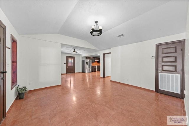 2307 Carlos Ave, Brownsville, TX 78526 - unfurnished living room featuring a notable chandelier, light tile patterned floors, lofted ceiling, visible vents, and baseboards