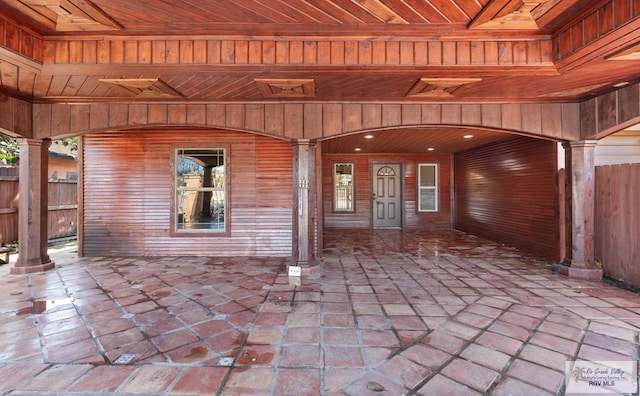 entrance to property featuring fence and a patio