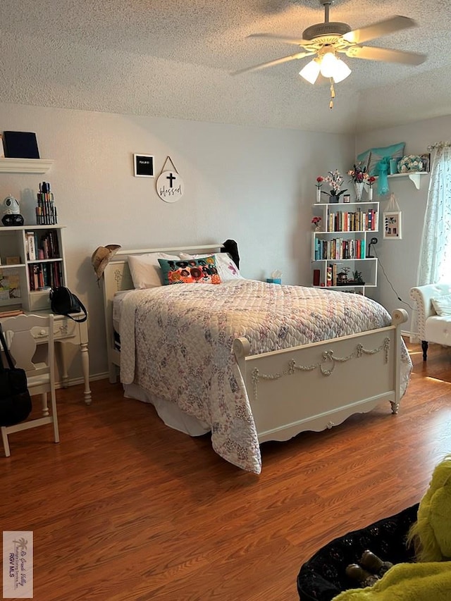 bedroom featuring ceiling fan, hardwood / wood-style flooring, and a textured ceiling