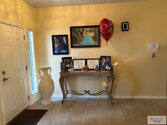 tiled entrance foyer with a textured ceiling