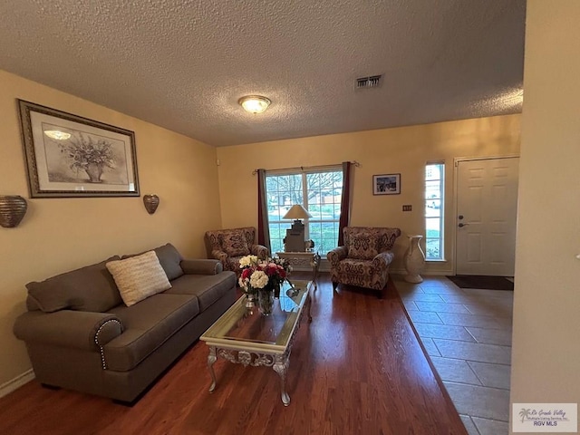 living room featuring a textured ceiling and dark hardwood / wood-style flooring