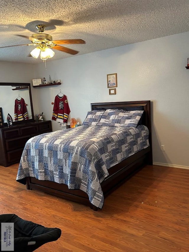 bedroom featuring ceiling fan, wood-type flooring, and a textured ceiling