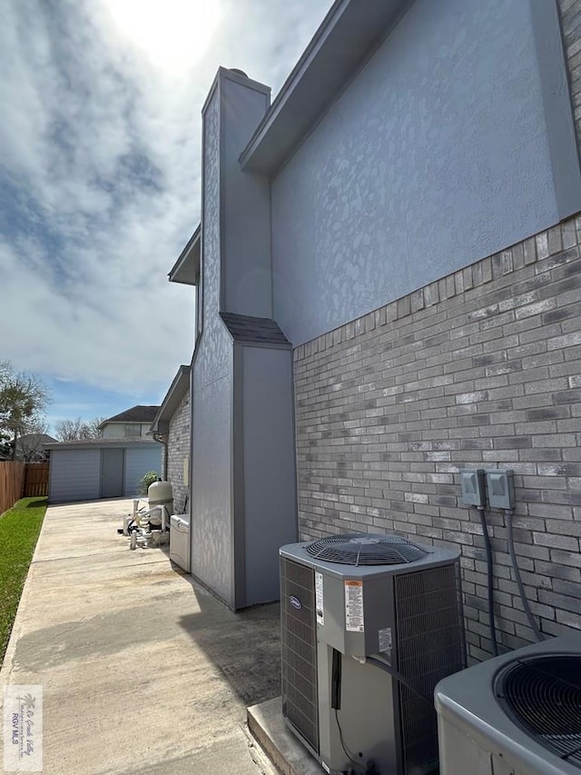 view of side of property featuring cooling unit, a garage, and an outdoor structure