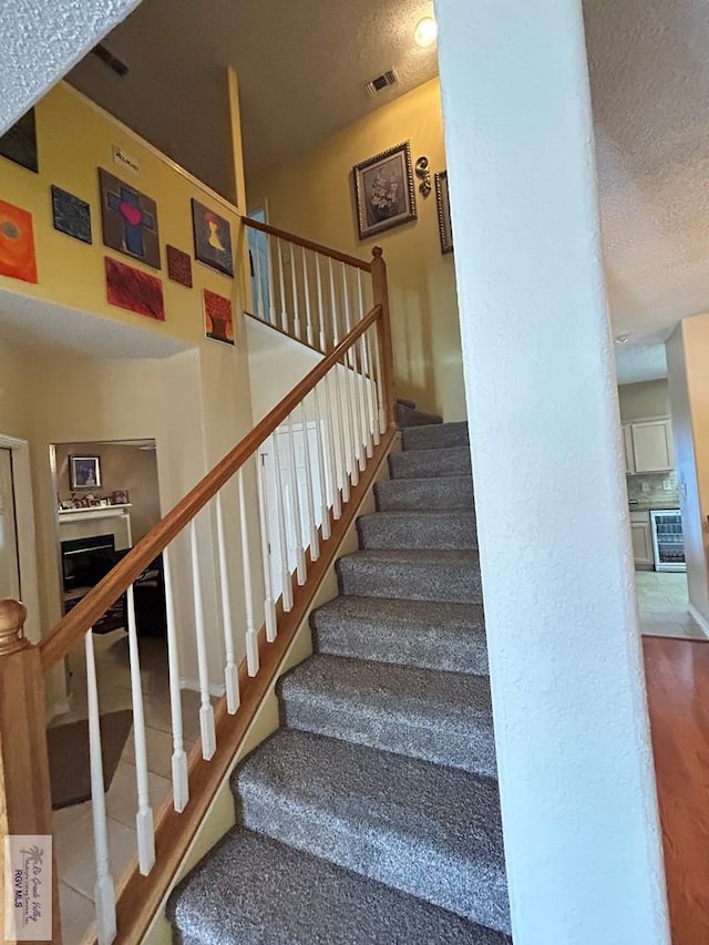 staircase featuring a textured ceiling