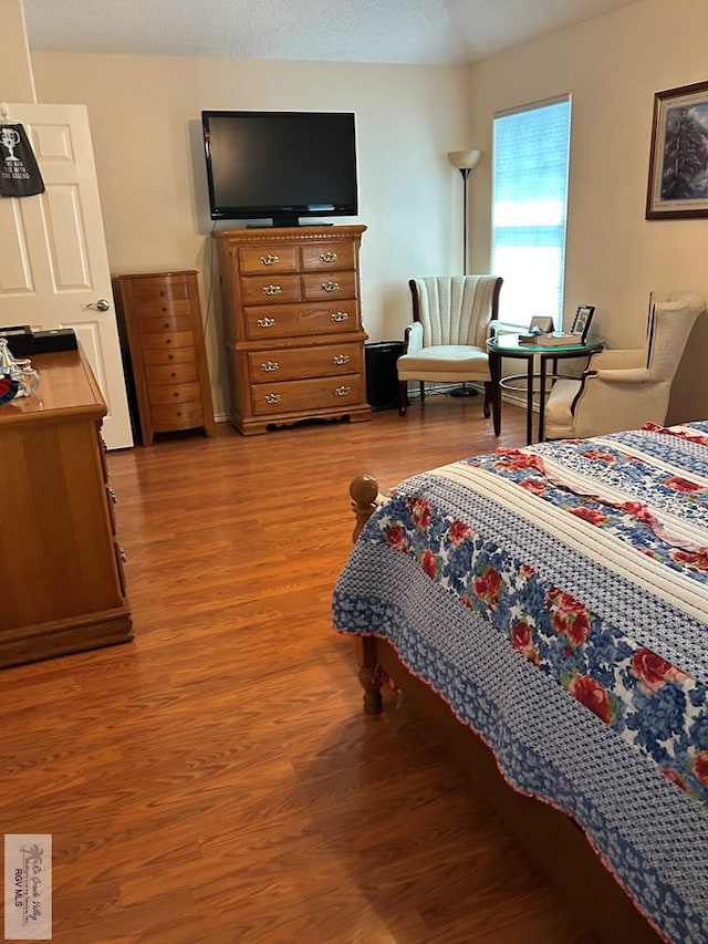 bedroom with hardwood / wood-style floors and a textured ceiling